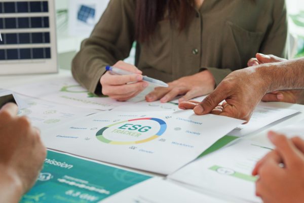 Closeup group Asia businesspeople talk ESG strategies risk management workshop, SDGs report, global warming, green finance investment eco friendly and net zero waste in boardroom training building.
